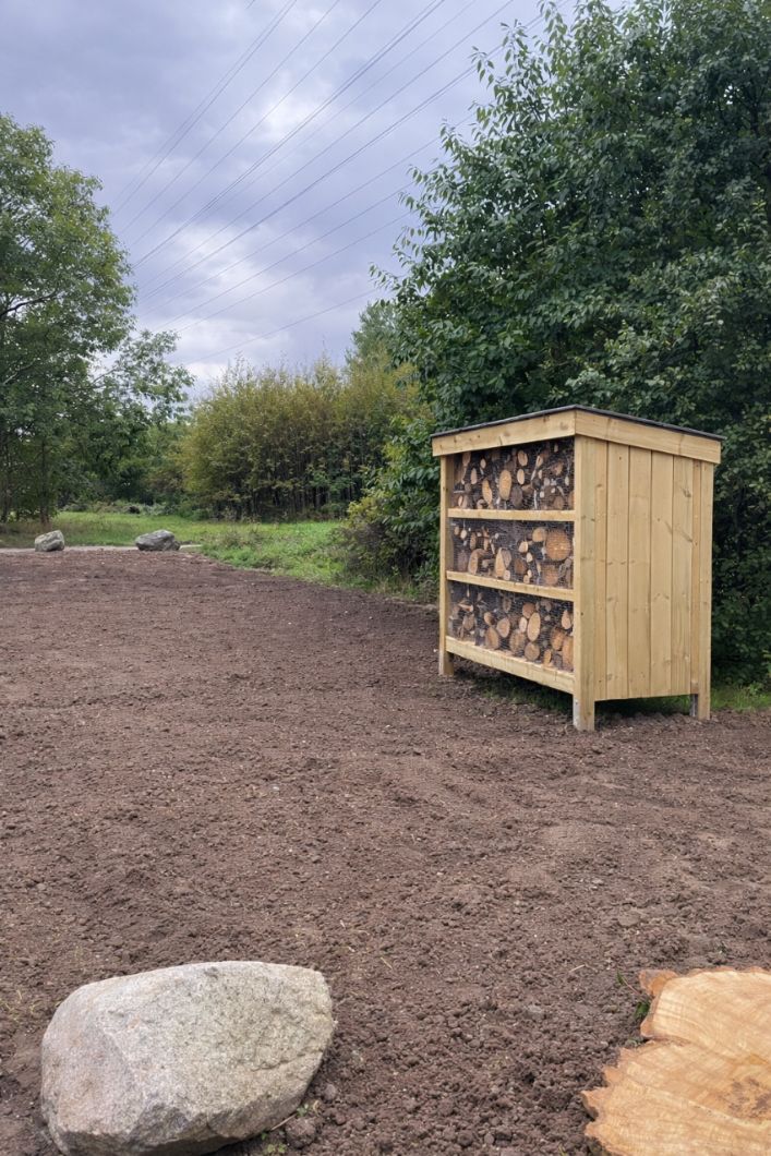 Stort insektshotell i trä placerat i park och grönområde skapar tydliga boplatser för bin och insekter och bidrar till ökad biologisk mångfald