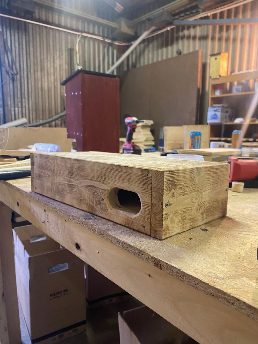 Tornseglarholk i bränt trä under tillverkning på arbetsbänk visar ingång och konstruktion för fågelholk för tornseglare