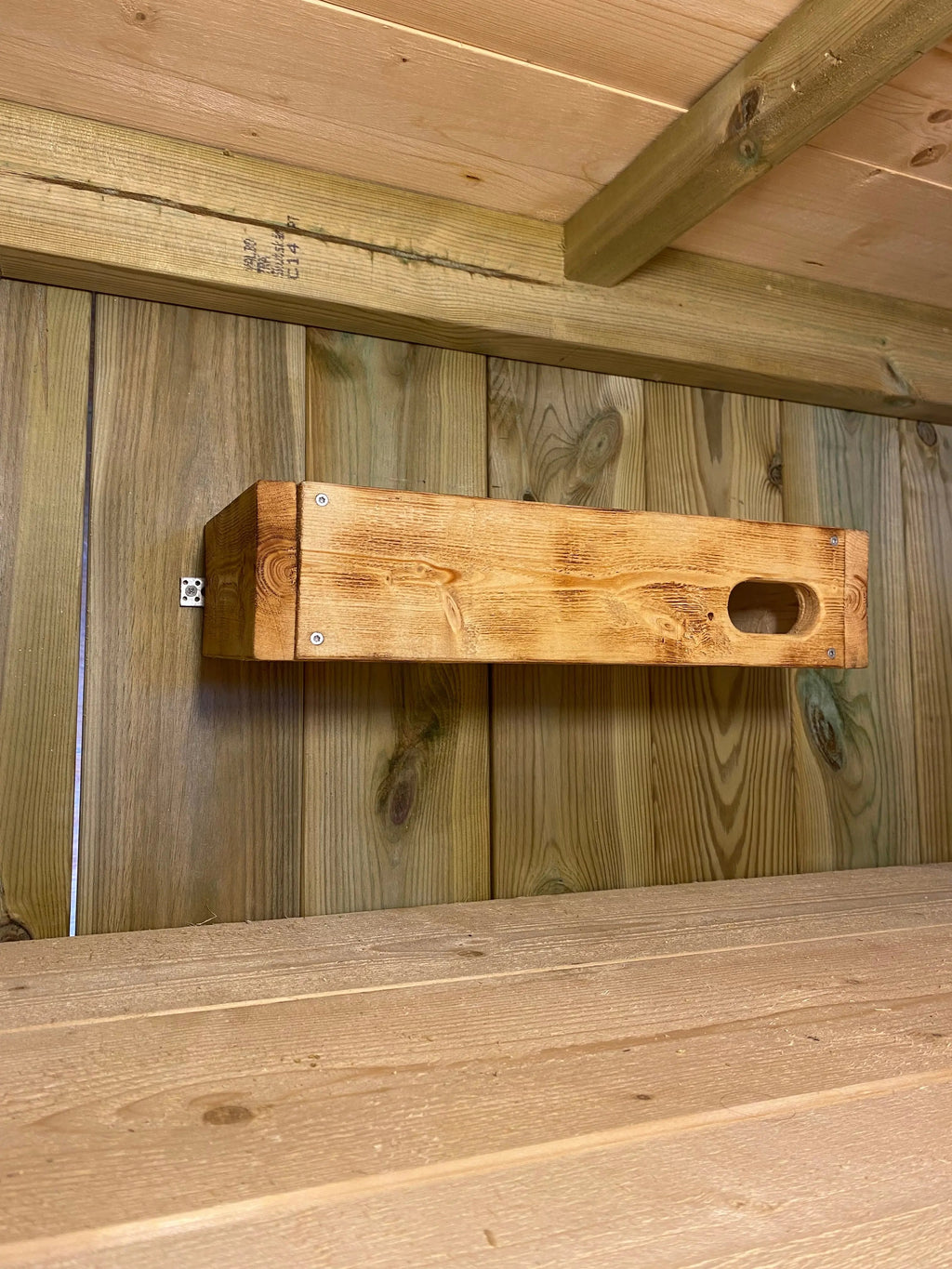 Bränd tornseglarholk i trä monterad på fasad under takfot som fågelholk för tornseglare